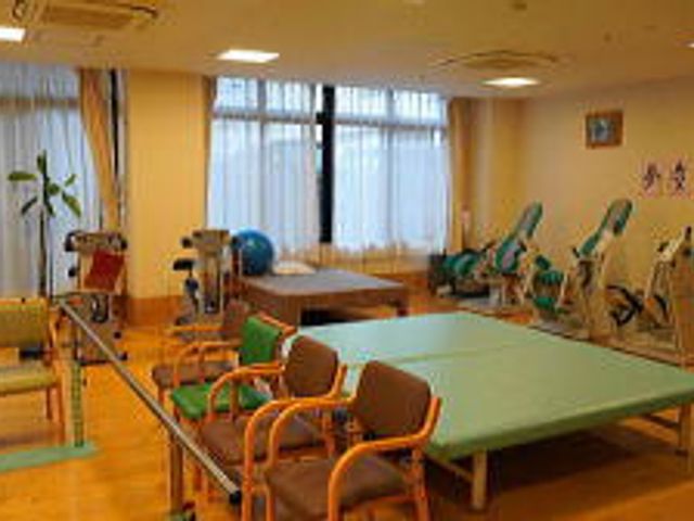 リハビリ用具と机の部屋 機能訓練室 自然光あふれる空間で、リハビリ用の設備が充実しています。スタッフによるサポートも万全です。