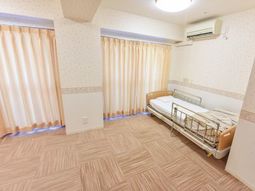 広々居室のベッドと窓