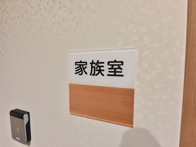 掲示された案内板 家族室 温かみのある木目調で配された案内板が、訪れた方に明確な案内を提供しています。