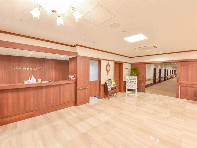 清潔感のあるエントランス 受付 エレガントな調度のある受付スペースが、来訪者の方をあたたかくお迎えします。明るく広々とした通路は、日々の業務にも気持ちよく取り組める環境を提供しています。