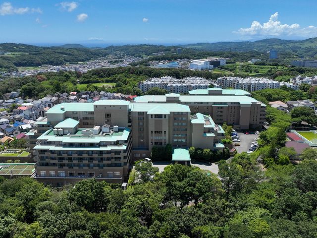 緑に囲まれた建物の外観 外観 緑豊かな環境に位置し、落ち着いた雰囲気の中で働けます。開放感のある設計が特徴です。