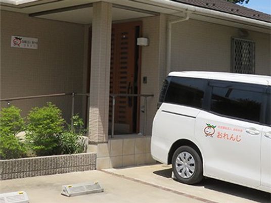 建物入口と送迎車の外観  