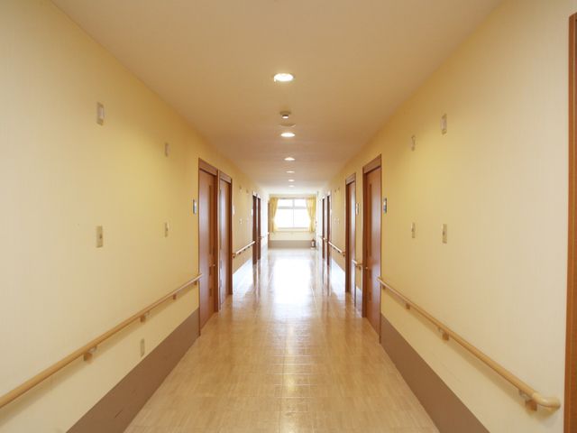 明るい廊下の風景 廊下 床が滑りにくい素材でできた廊下は、手すりが整備されており、歩行に安心感を提供しています。