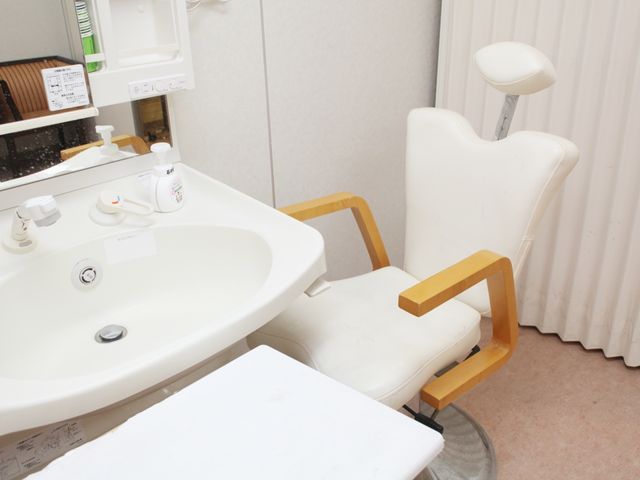 洗面台と診察用椅子 洗面台 清潔感のある洗面スペースには、利便性を考えた設計の診察用椅子が設置され、使い勝手が良さそうです。