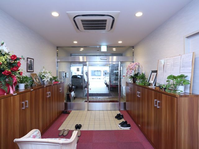 清潔感のあるエントランス 玄関 玄関には鮮やかな花が飾られ、訪れる方を温かく迎えます。整った環境で、快適な勤務を実現できる空間です。
