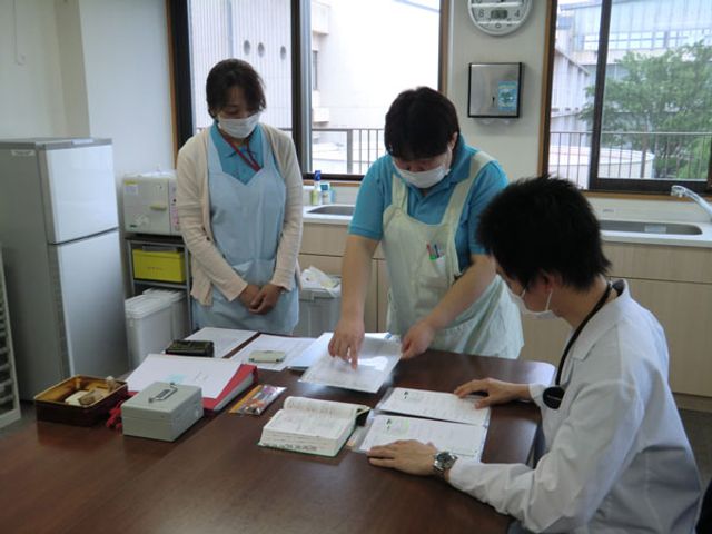 職員が話し合うラウンジ ラウンジ 明るいラウンジで、職員が資料を見ながら話し合っています。快適なコミュニケーション環境です。