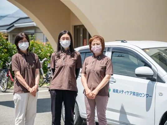 スタッフ3人と送迎車の外観