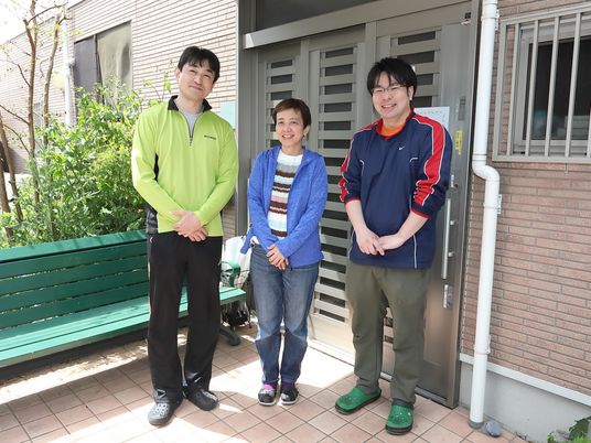 笑顔で立つスタッフ三名