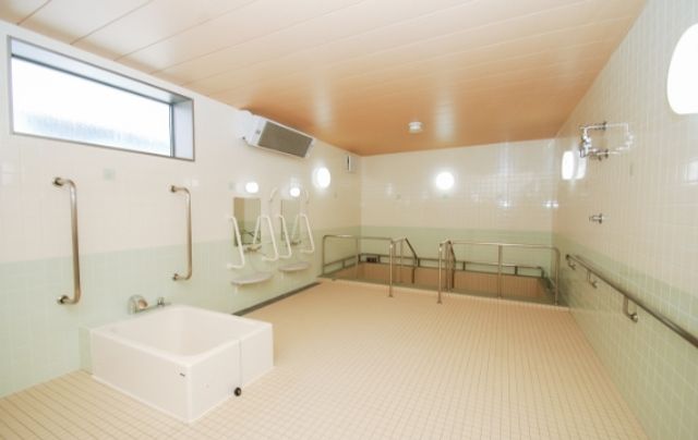 入浴設備が整った部屋 浴室 広々とした空間で、明るい自然光のもとで安心して入浴を楽しめます。手すりが充実しており、安全に配慮されています。