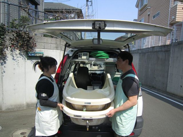 福祉車両での作業 スタッフイメージ スタッフが協力して福祉車両から機器を搬送しています。チームワークが重要です。