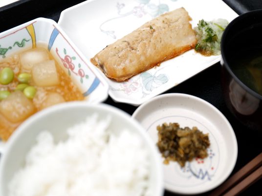 焼き魚が、この日のメインのおかずである。色とりどりの絵柄の付いた小鉢やお皿に並べられていて、シンプルな料理を引き立てている。