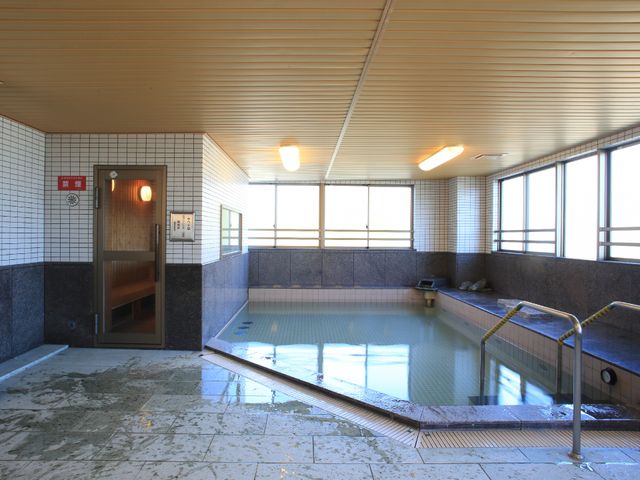 ゆったり浴室と入口 大浴場 広々とした清潔感ある浴室で、安らぎのひとときを提供しております。ゆっくりと体を癒せる環境です。
