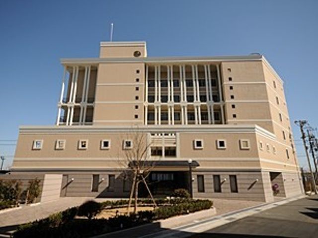 落ち着いた色合いの建物正面 外観 広々とした前庭を備え、穏やかな色調のモダンな建物が、働く環境の快適さを感じさせます。