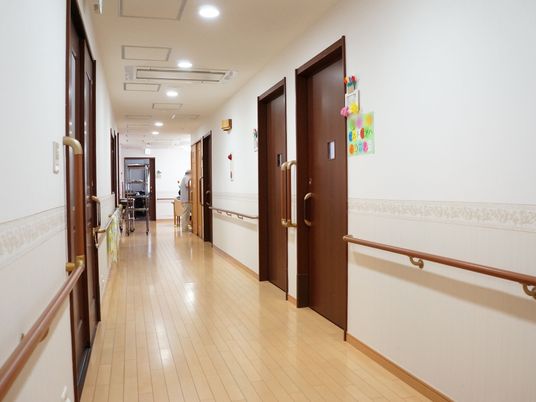 廊下の左右には、焦げ茶色の扉が並んでいる。各扉の脇には垂直に手すりが付いており、廊下の両壁面にも歩行を助ける手すりが取り付けられている。