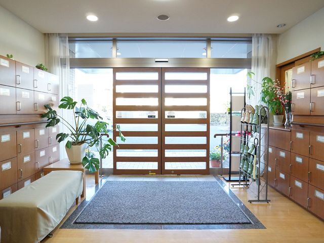 明るいエントランスと靴箱 玄関 広々としており、木製の靴箱も美しいエントランスです。待合には植物もあり、心地よい雰囲気で迎えてくれます。