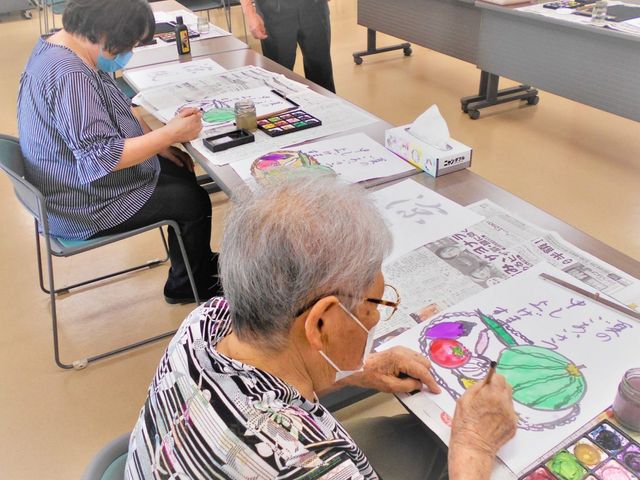 多世代が集う活動スペース 多目的室 色とりどりの絵の具で画用紙に絵を描く、明るい表情の方々。創作活動を通じて、皆で楽しく交流しています。
