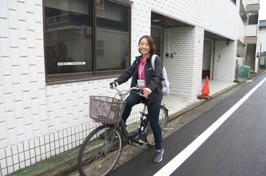 笑顔の職員と自転車
