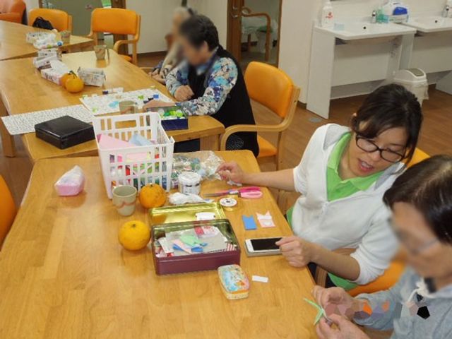 談話しながら作業する様子のテーブル 中庭 広いテーブルでは、利用者同士が集い作業をしながら交流できるスペースになっています。