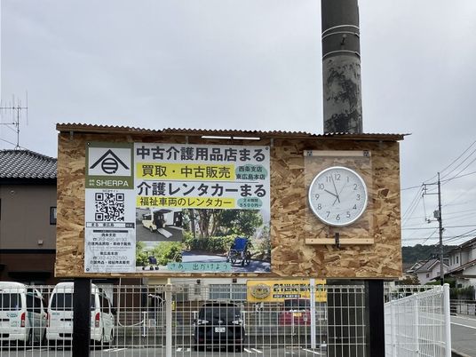看板と時計のある外観  