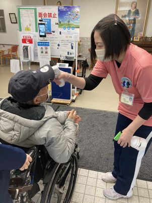 受付での体温測定シーン