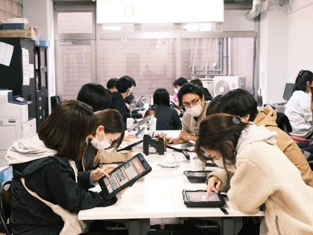スタッフの会議室 スタッフイメージ スタッフがテーブルを囲んで、タブレットを使いながらミーティングを行っています。リラックスした雰囲気が感じられます。