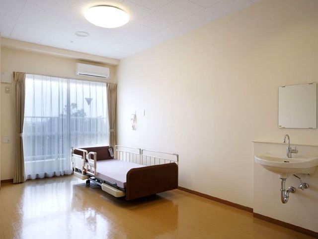 シンプルな居室 居室 明るい居室には大きな窓があり、自然光がたっぷりと差し込んでいます。ベッドと洗面台が設置されています。
