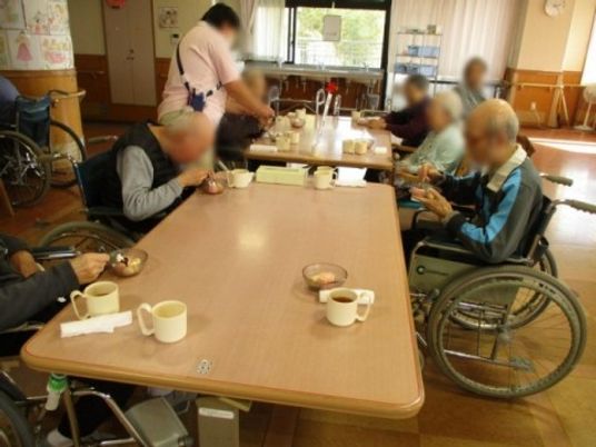 車椅子で食事を取る場面