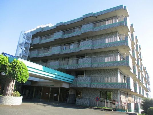 緑に囲まれた建物の外観  