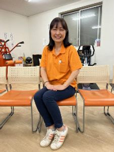 笑顔の女性と椅子が並ぶ部屋  