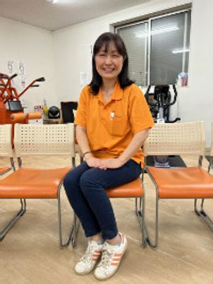 笑顔の女性と椅子が並ぶ部屋  