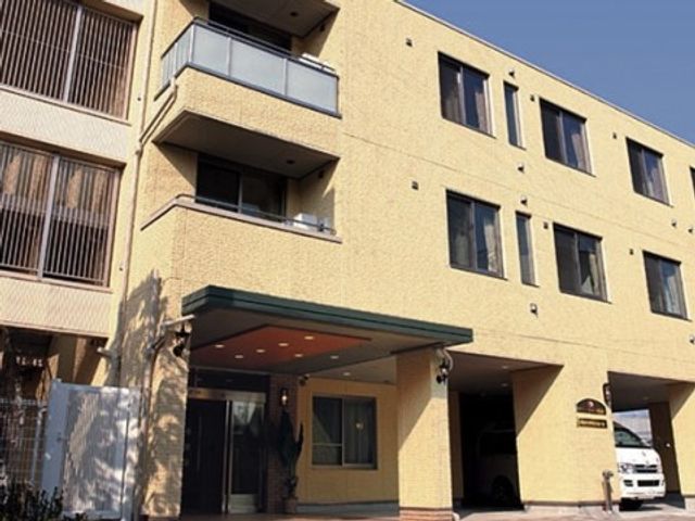 黄色い建物のエントランス 施設外観 開放感のある広々としたエントランスです。日当たりがよく、明るい印象を受ける外観が特徴です。
