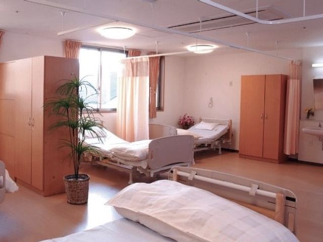 広々とした居室空間 居室・４人部屋 日当たりの良い居室で、ゆとりを持って過ごせる環境が整っています。緑の植物が心地よいアクセントとなり、温かみのある雰囲気を醸し出しています。