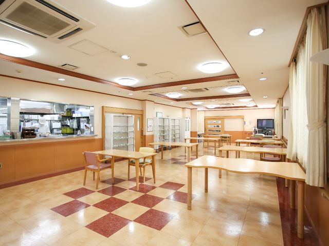 暖かみのあるダイニングルーム 食堂 開放的な空間で職員が調理する様子が見え、安心感を与えます。
