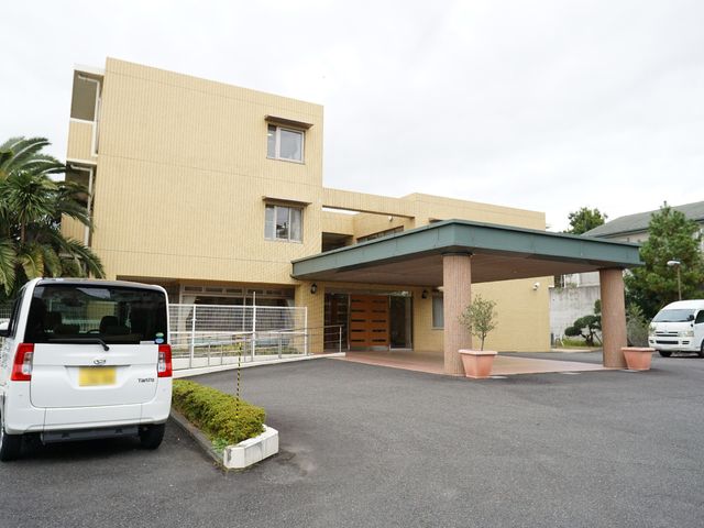 黄色い建物のエントランス 外観 明るい色合いの建物前には、広々としたスペースがあります。アクセスしやすいエントランスが迎えてくれます。