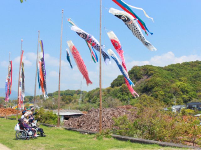 青空の下、庭 庭 青空と緑に囲まれた庭では、人々が鯉のぼりを眺めてくつろいでいます。心地よい時間を過ごせます。