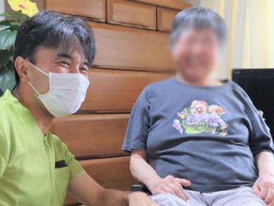 笑顔の介護士と利用者、居室