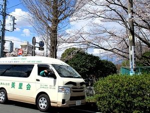 送迎車と桜並木の外観  