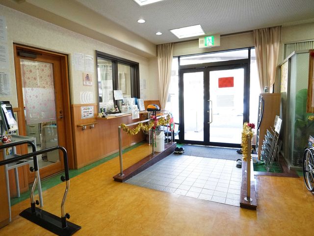 受付と出入口の風景 玄関 明るく開放的な入り口は、暖かい歓迎の雰囲気を創出しています。適時に情報提供も行われており、安心できる環境が整っています。
