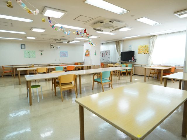 明るい多目的スペース 共有スペース カラフルな椅子が並ぶ活動室です。ゆったりと利用者の交流が行われます。