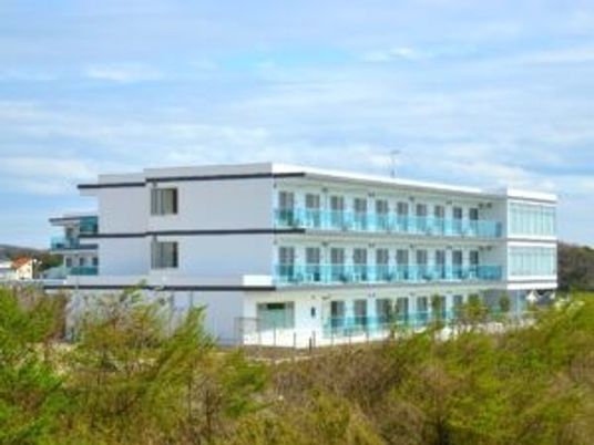 白い3階建て施設外観  
