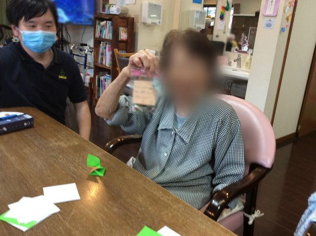 明るい居室 居室 広いスペースの居室で、利用者がリラックスしながら折り紙を楽しんでいます。人々の和やかな交流の場にもなっています。