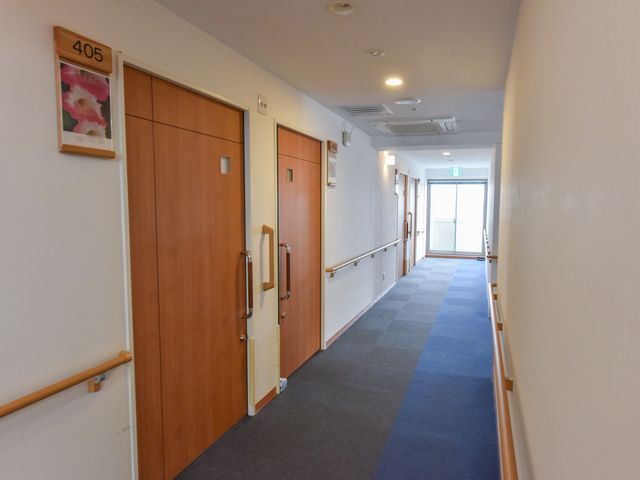 明るく清潔な廊下 通路 ゆとりのある通路は、明るく開放的な雰囲気を醸し出しており、働く環境としても快適です。壁には番号と絵が飾られ、視覚的なガイドも提供しています。