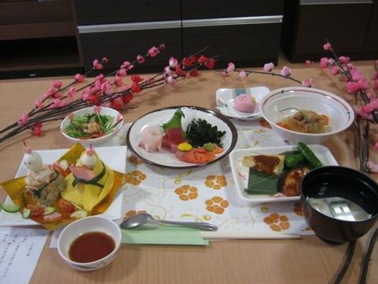 ひな祭りの食事の一例。ひな人形を形取ったごはんや刺身、お吸い物、サラダなどが彩りよく並べられている。