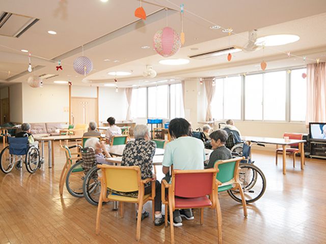 広いリビング リビング 車椅子の方々が集まり、和やかに交流できる広々とした空間が広がっています。自然光が差し込む明るさも魅力です。