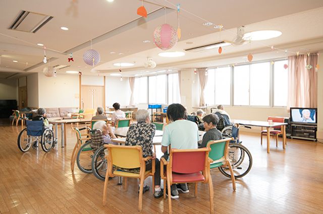 広いリビング リビング 車椅子の方々が集まり、和やかに交流できる広々とした空間が広がっています。自然光が差し込む明るさも魅力です。