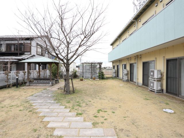 緑豊かな庭の風景 中庭 広々とした静かな庭があり、季節の変化を肌で感じながら休息できる理想的な環境です。温もりあるスペースで心地よい時間を過ごせることでしょう。