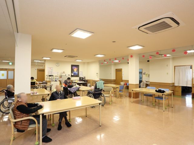 広々とした明るい居室 共有スペース ゆとりのあるスペースで、談笑しながら過ごす人々が映る居室です。ここでのひとときは、共に暮らす仲間との暖かな交流の時間となります。