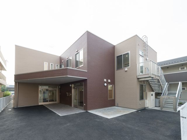 現代的な建物の外観 外観 落ち着いた色調のモダンな建物で、広々とした駐車スペースがあります。看板がきちんと設置され、施設へのアクセスが良好です。