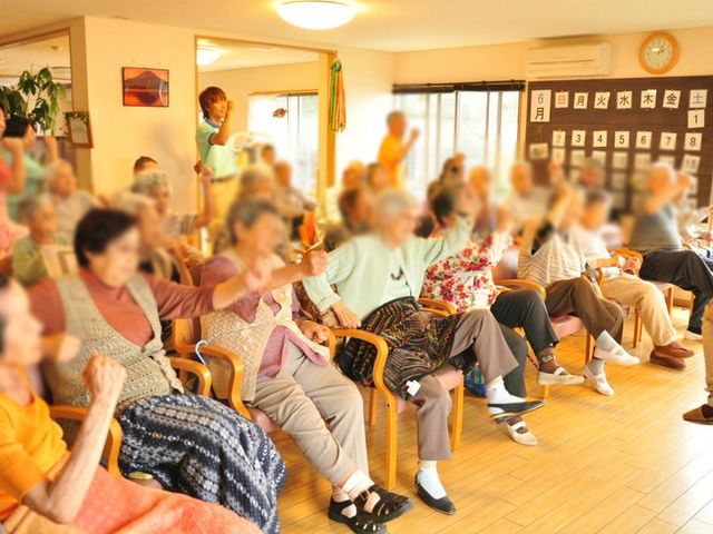 広々とした共有スペース リビング 開放感のある明るい空間で、利用者の方々がくつろいで楽しんでいる様子が伺えます。