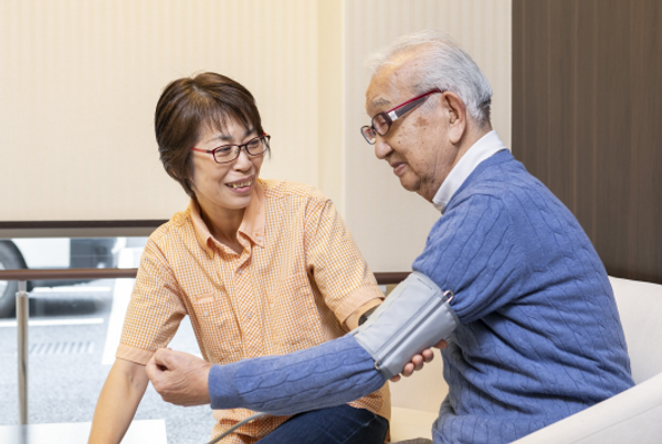 血圧測定をするスタッフと利用者